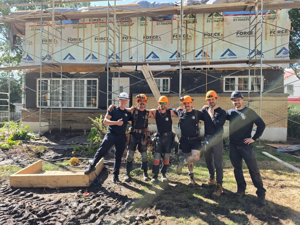 photo de groupe de l'équipe i9 construction le sourire au visage sur un chantier.