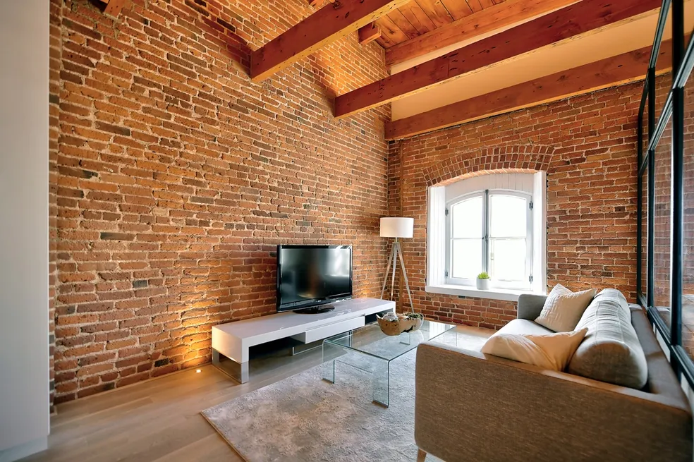 photo d'une rénovation haut de gamme effectué par i9 construction d'un salon avec télévision dans un studio situé au vieux québec.